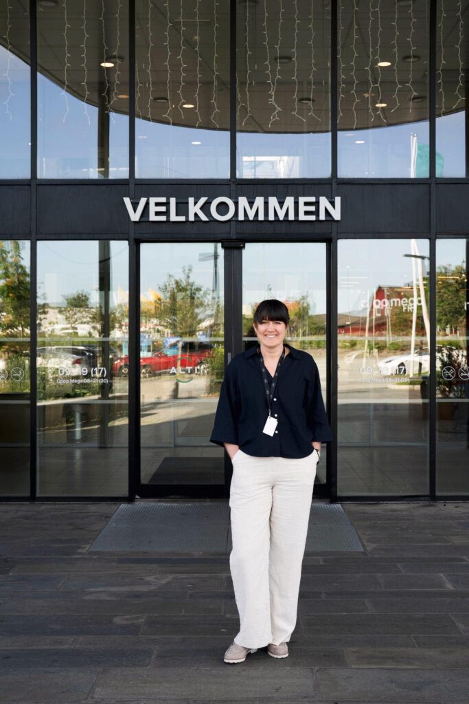 Gunn Berit Frøyland foran hovedinngangen til Alti Nærbø