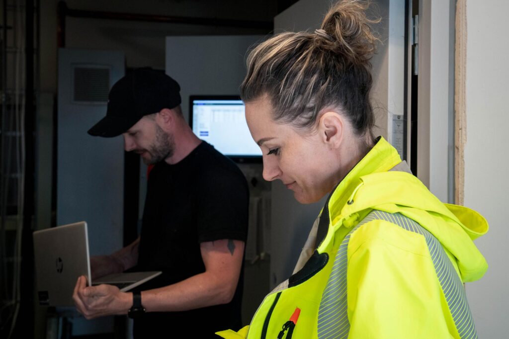 To prosjektmedarbeidere bruker digitale verktøy på byggeplassen